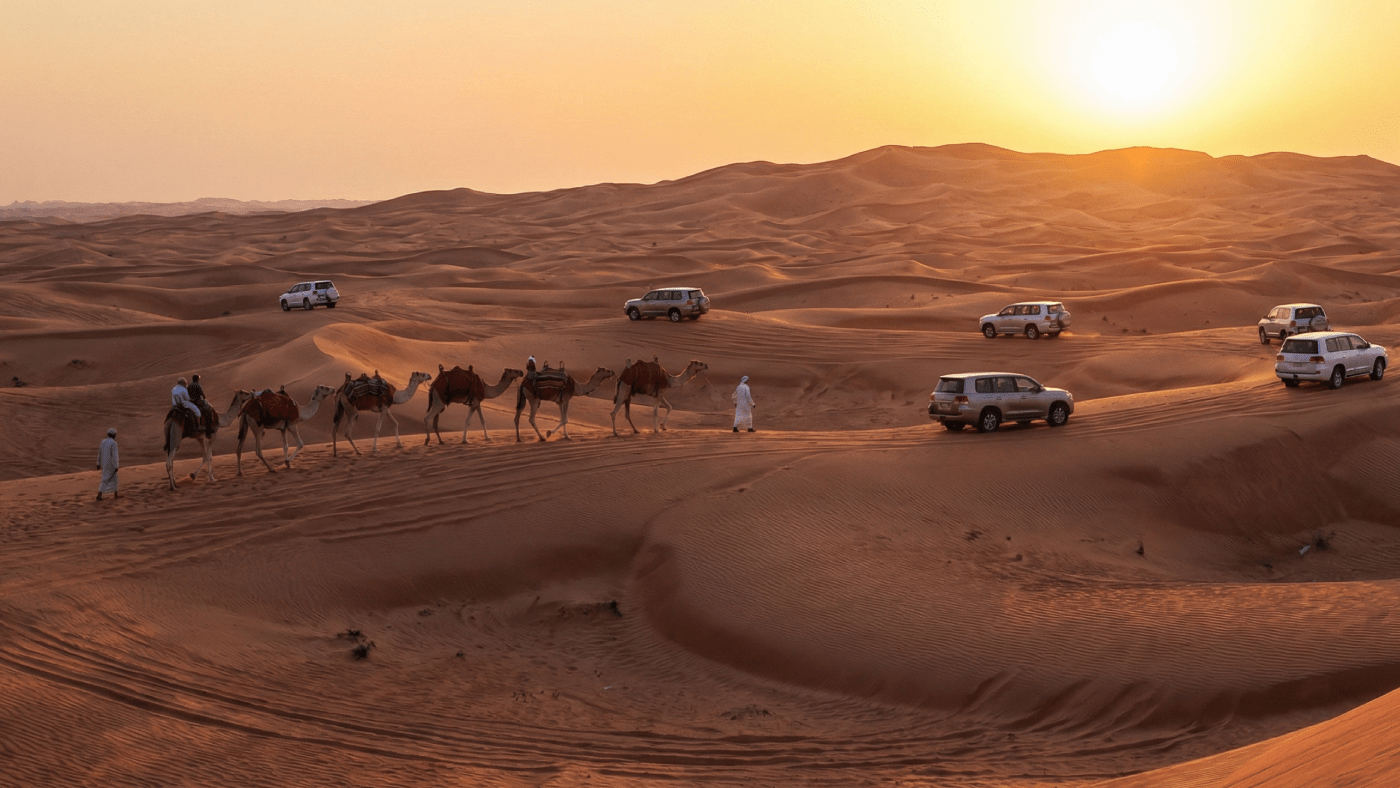 AI Generated Image of a sunset desert safari in Dubai, featuring a camel caravan ridden by men and several 4x4 vehicles parked on the dunes.